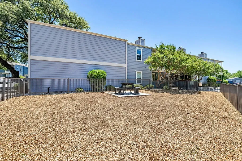 Pet park with picnic table and mulch ground cover.