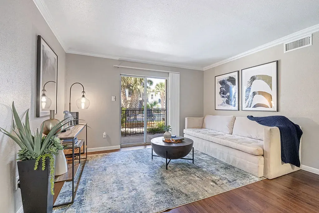Bright living room with a white sofa, coffee table, and balcony view.