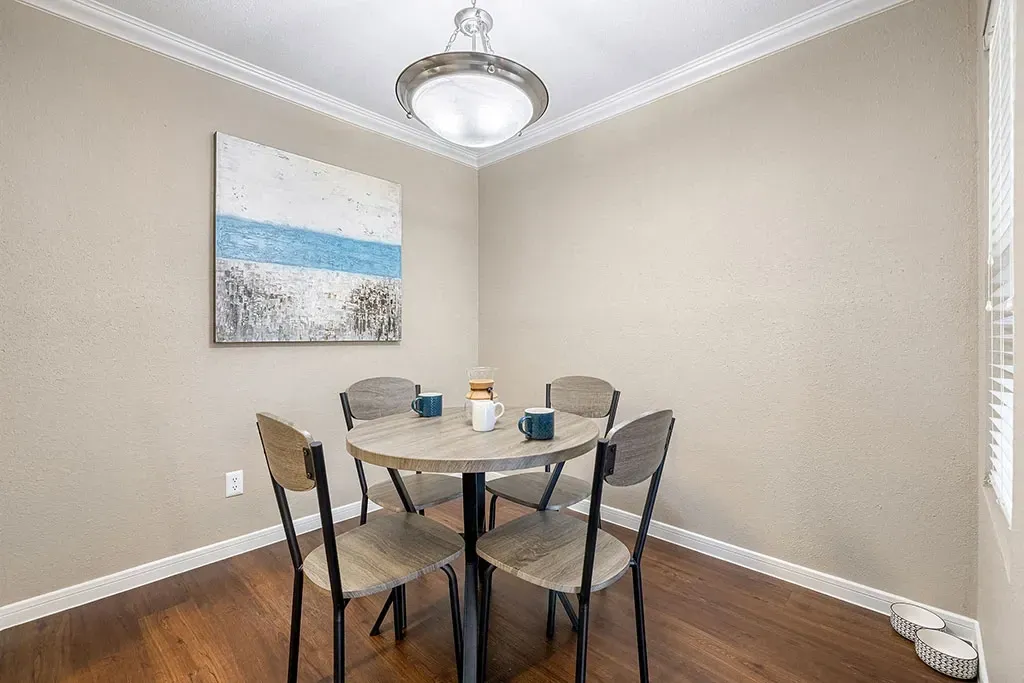 Dining area with a round table, four chairs, and a coffee maker.