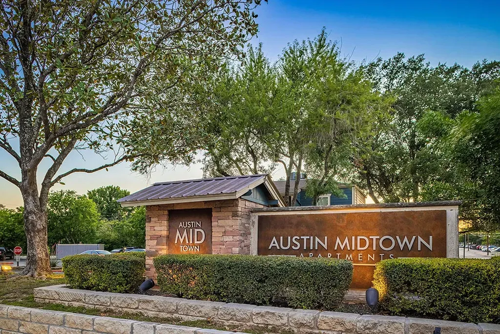 Austin Midtown Apartments monument sign with brick accents and landscaping.