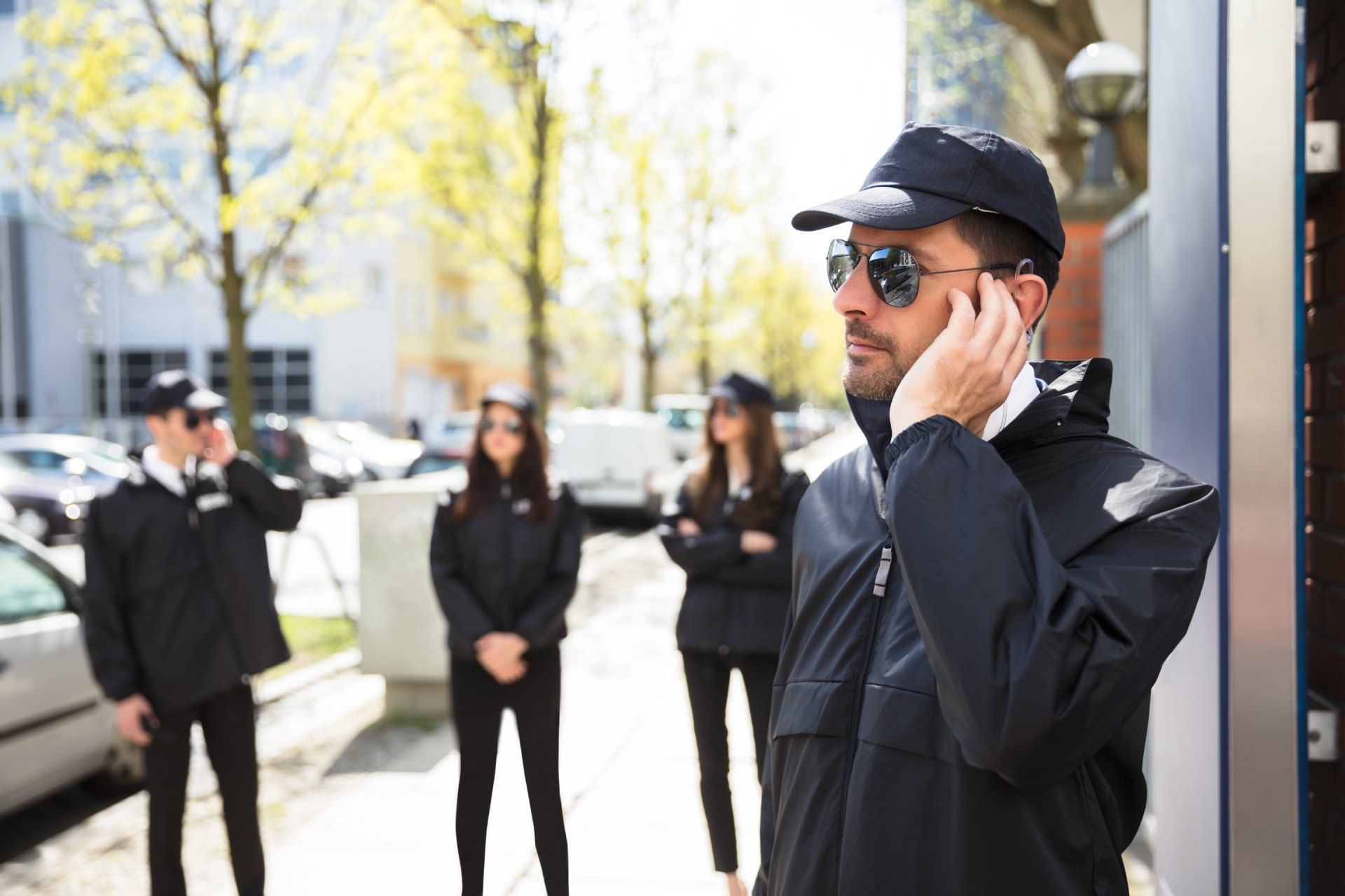 A man is talking on a cell phone while standing next to a group of security guards.