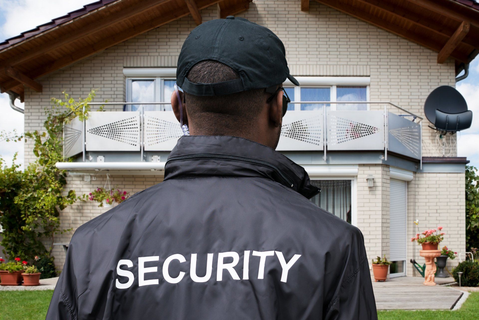 A security guard is standing in front of a house.