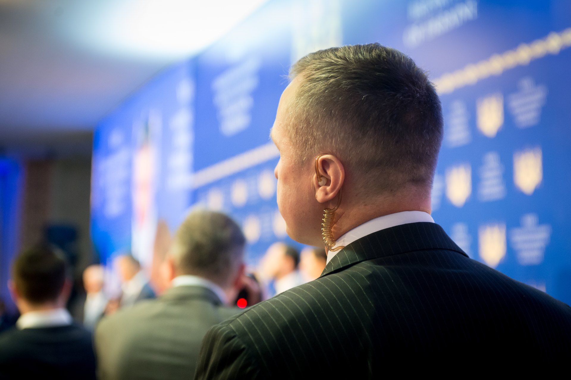 A man in a suit is standing in front of a crowd of people.