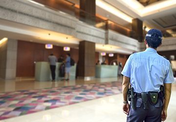 A security guard is standing in a hotel lobby.