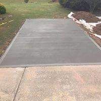A concrete driveway is being built in a backyard.