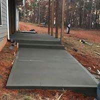 A concrete walkway is being built in front of a house.