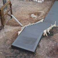 An aerial view of a concrete walkway being built in a yard.