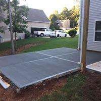 A concrete driveway is being built in front of a house.