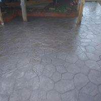 A close up of a concrete floor with a wooden fence in the background.