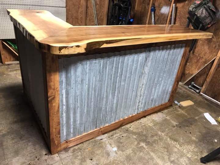 A wooden bar with a metal back is sitting in a garage.
