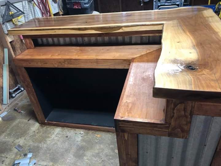 A wooden desk is sitting on a concrete floor in a garage.