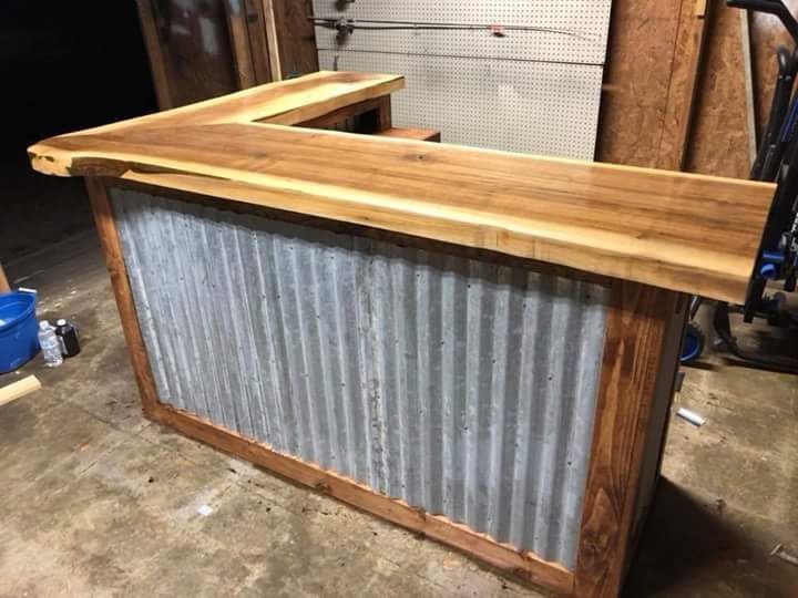 A wooden bar with a metal back is sitting in a garage.