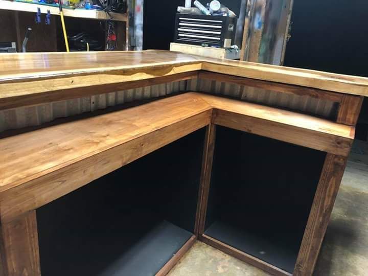A wooden table with a black shelf underneath it in a room.