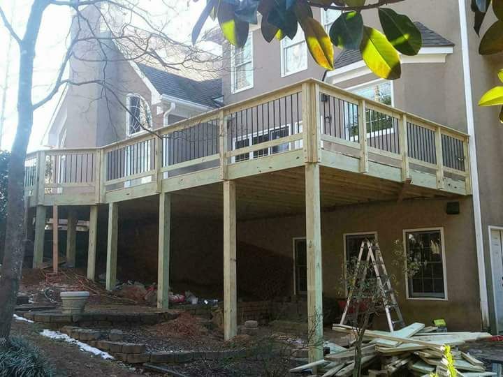 A large wooden deck is being built in front of a house.