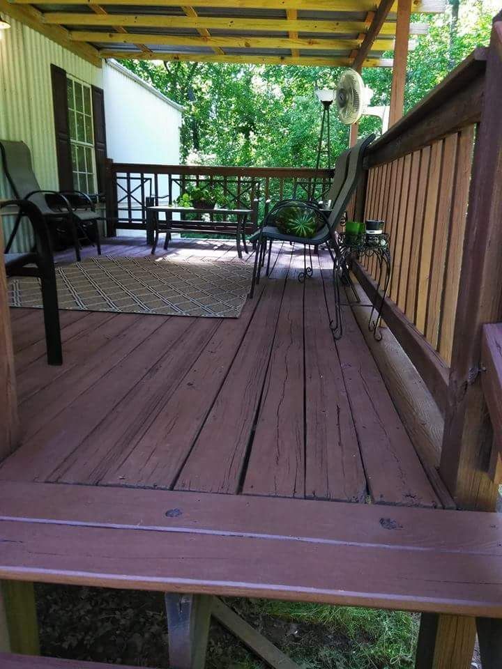 A wooden deck with chairs and a fan on it