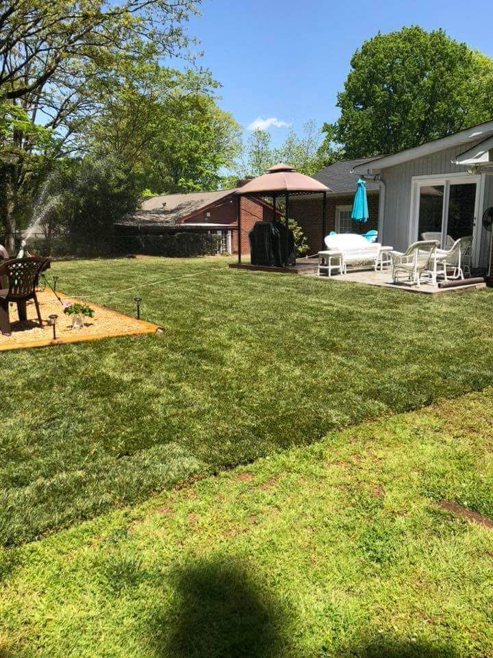 A backyard with a lush green lawn and a gazebo.