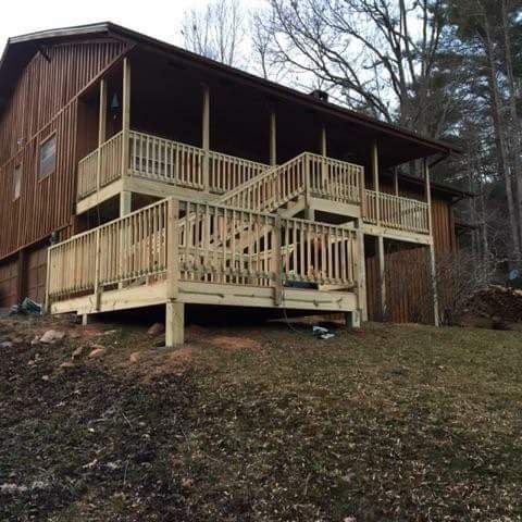 A large wooden house with a large deck and stairs.