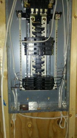 A close up of a electrical panel on a wooden wall.