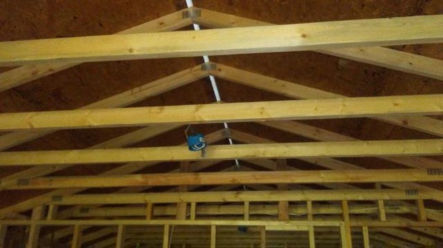A wooden ceiling with a blue light hanging from it.