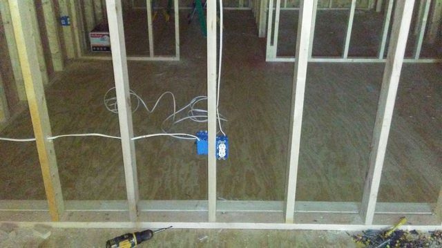 A room with a lot of wooden beams and a drill on the floor.