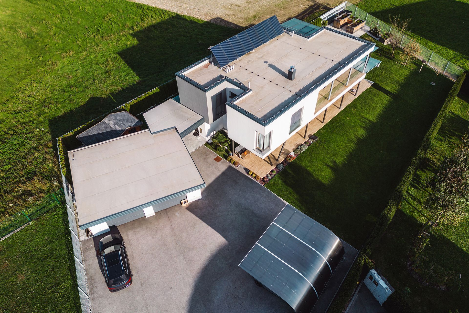 An aerial view of a house with a car parked in front of it