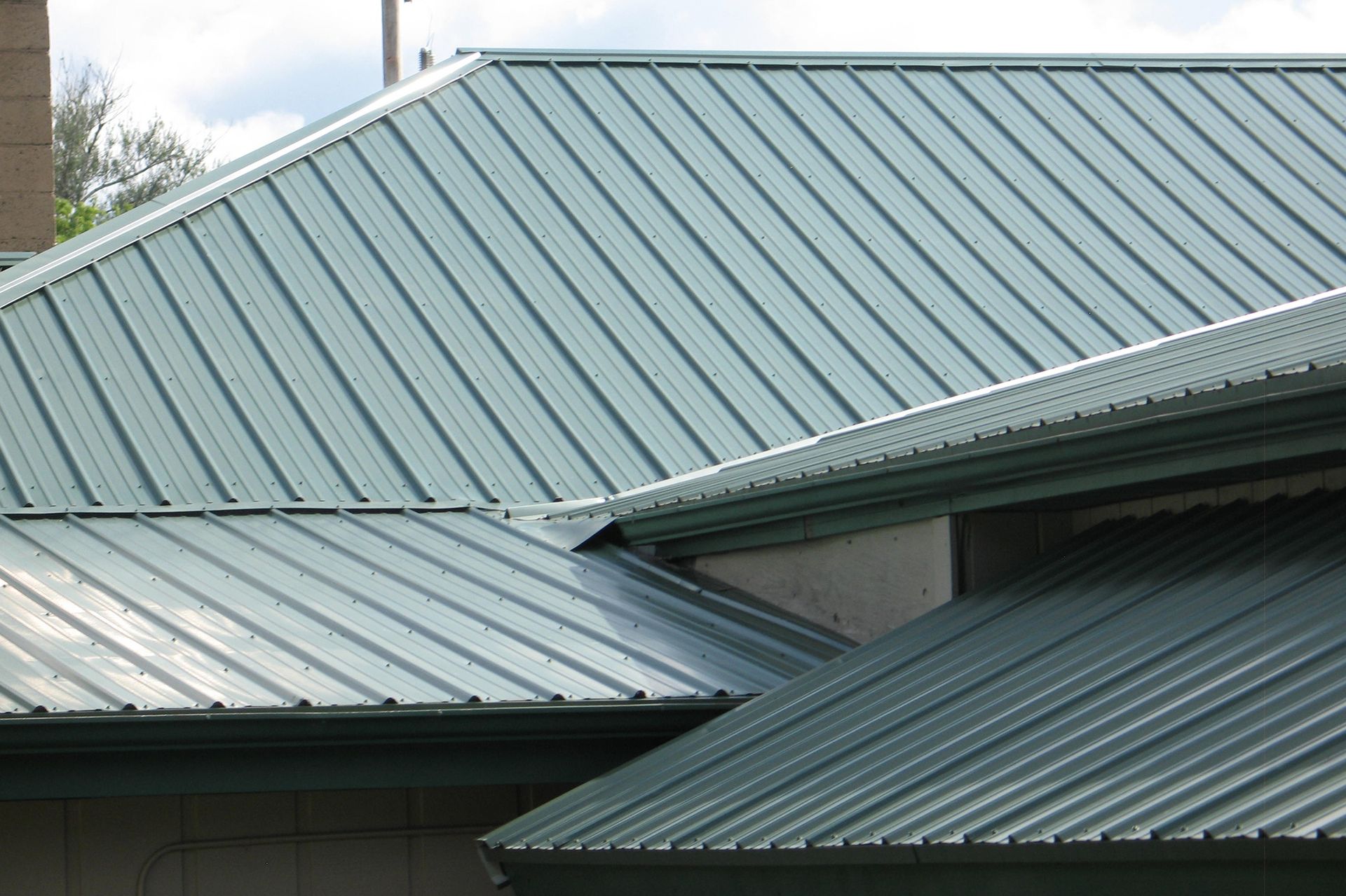 A close up of a green metal roof on a house.