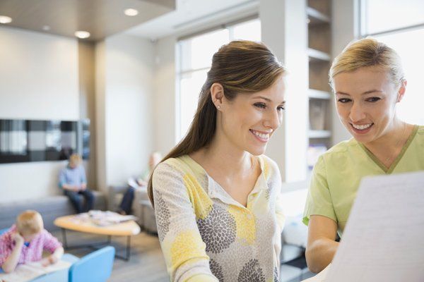woman with dentist explaining paperwork