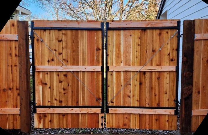 A wooden fence with a metal gate in front of a house