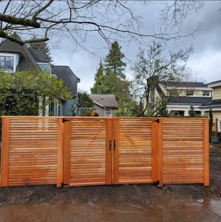 A wooden fence with a gate in front of a house
