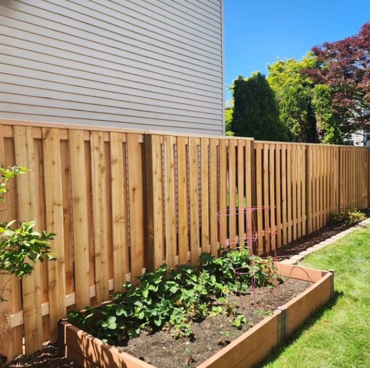 A wooden fence with a garden in front of it