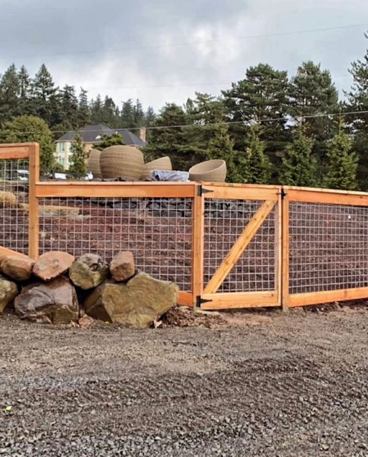 A wooden fence is surrounded by rocks and trees