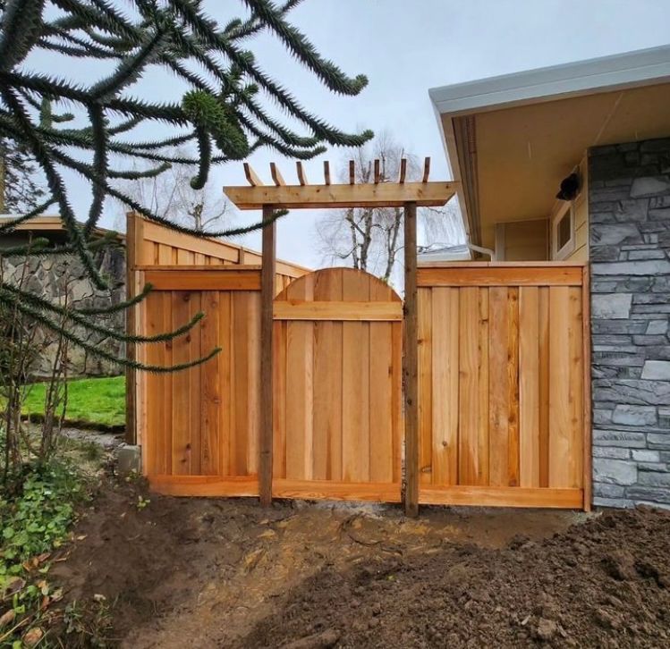 A wooden fence with a stone wall behind it