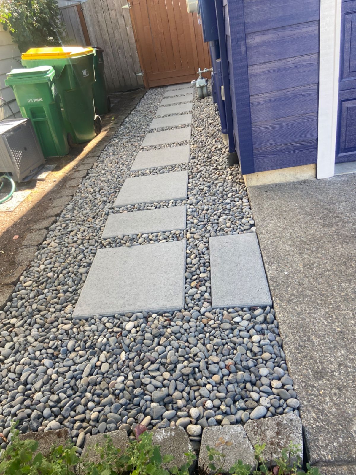 A stone walkway leading to a purple garage door.