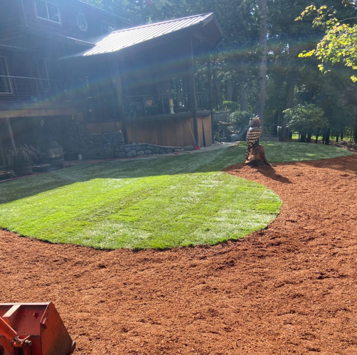 A large house is behind a lush green lawn
