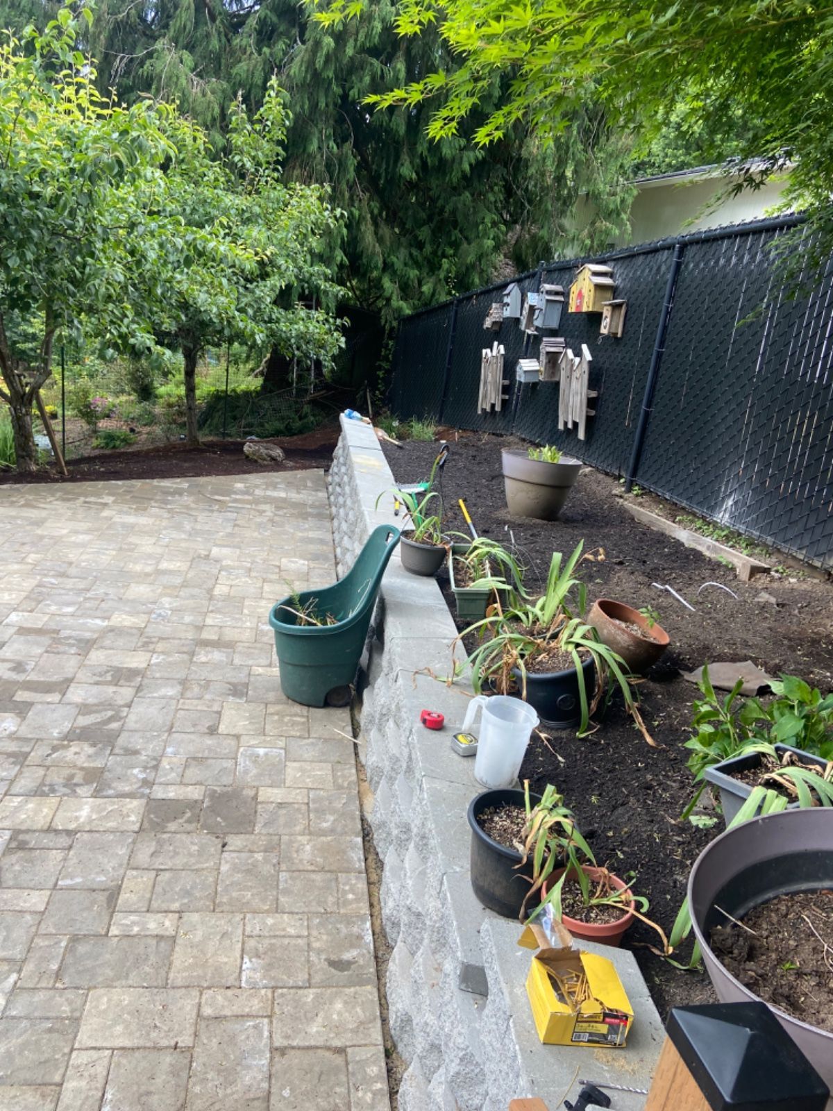 A patio with potted plants and a chain link fence.
