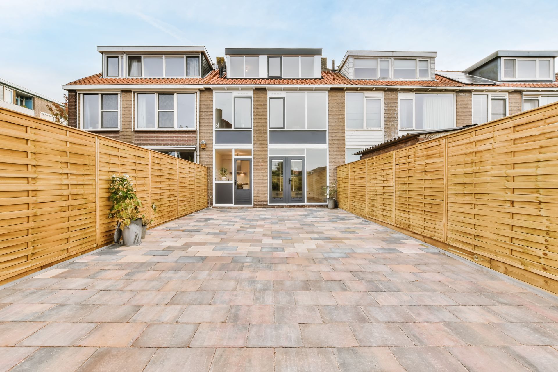 The backyard of a house with a wooden fence and a patio.