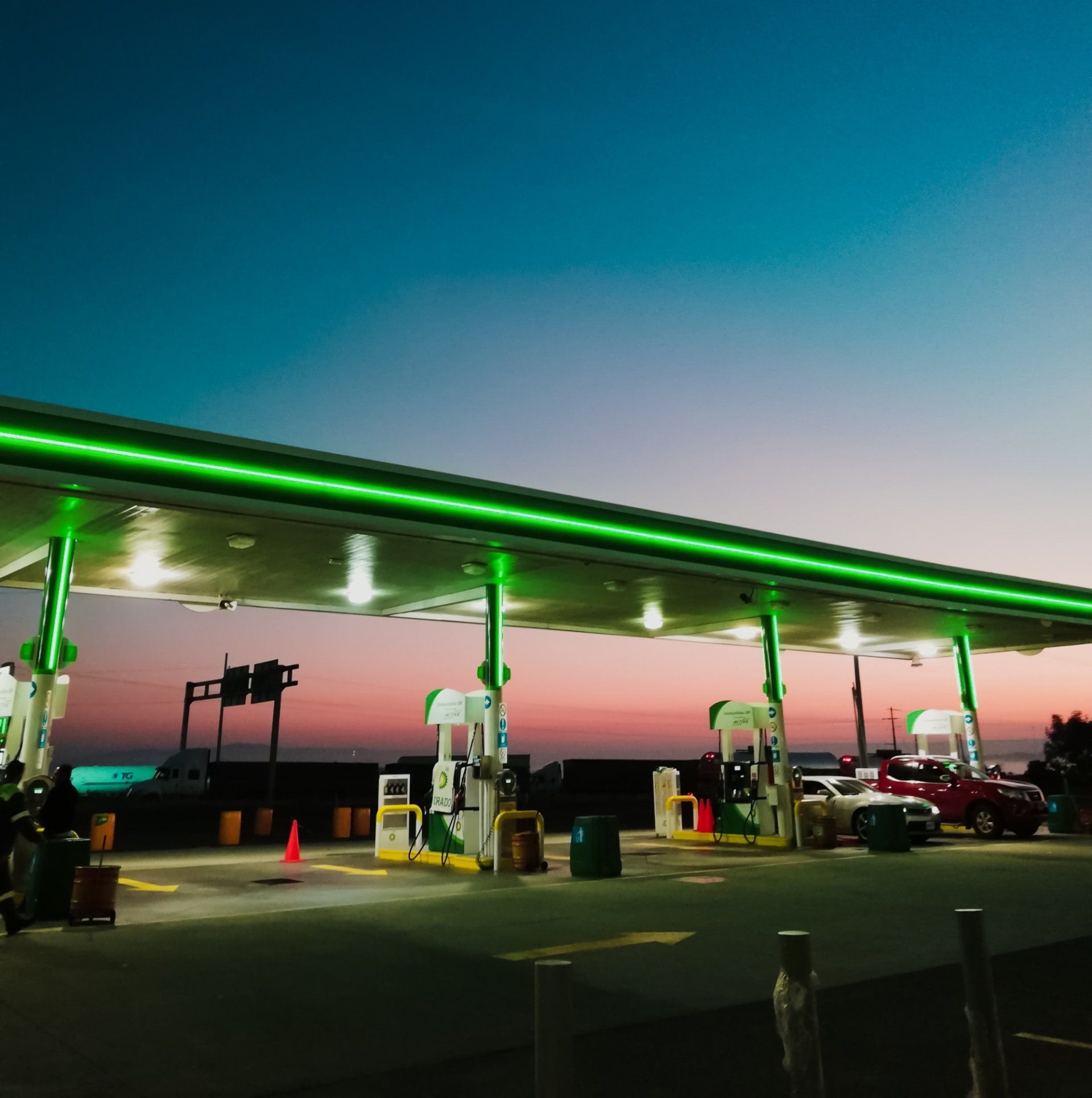 A gas station at night with green lights on the roof