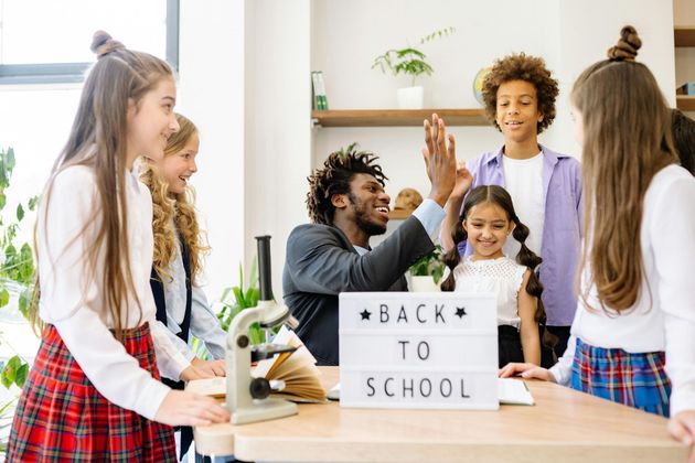 Teacher high-fives a student with a