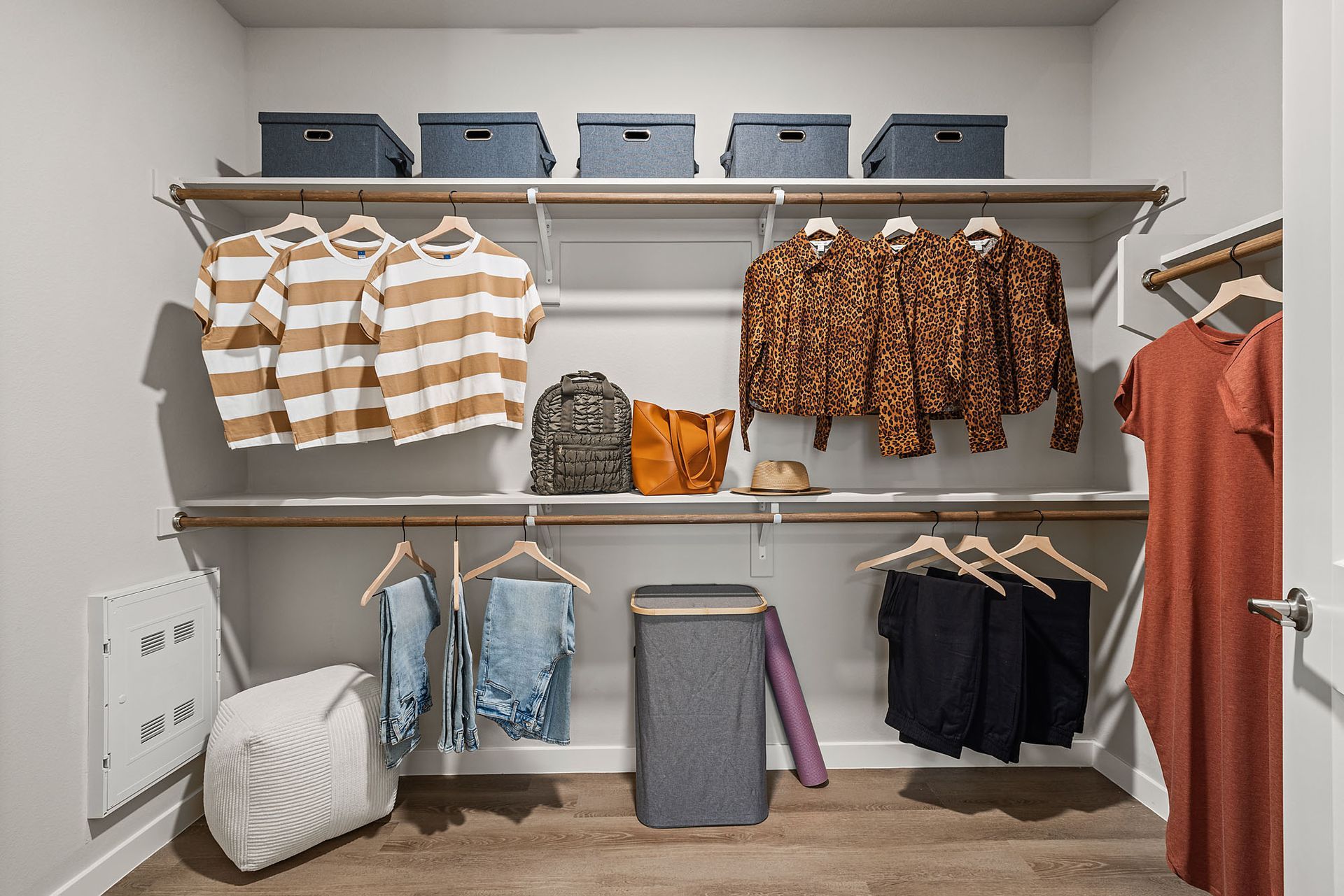 Walk-in closet with clothes hanging on shelves; storage bins on top shelf at Marq Bronco Butte, offers 1, 2, and 3 bedroom apartments in North Phoenix, AZ.