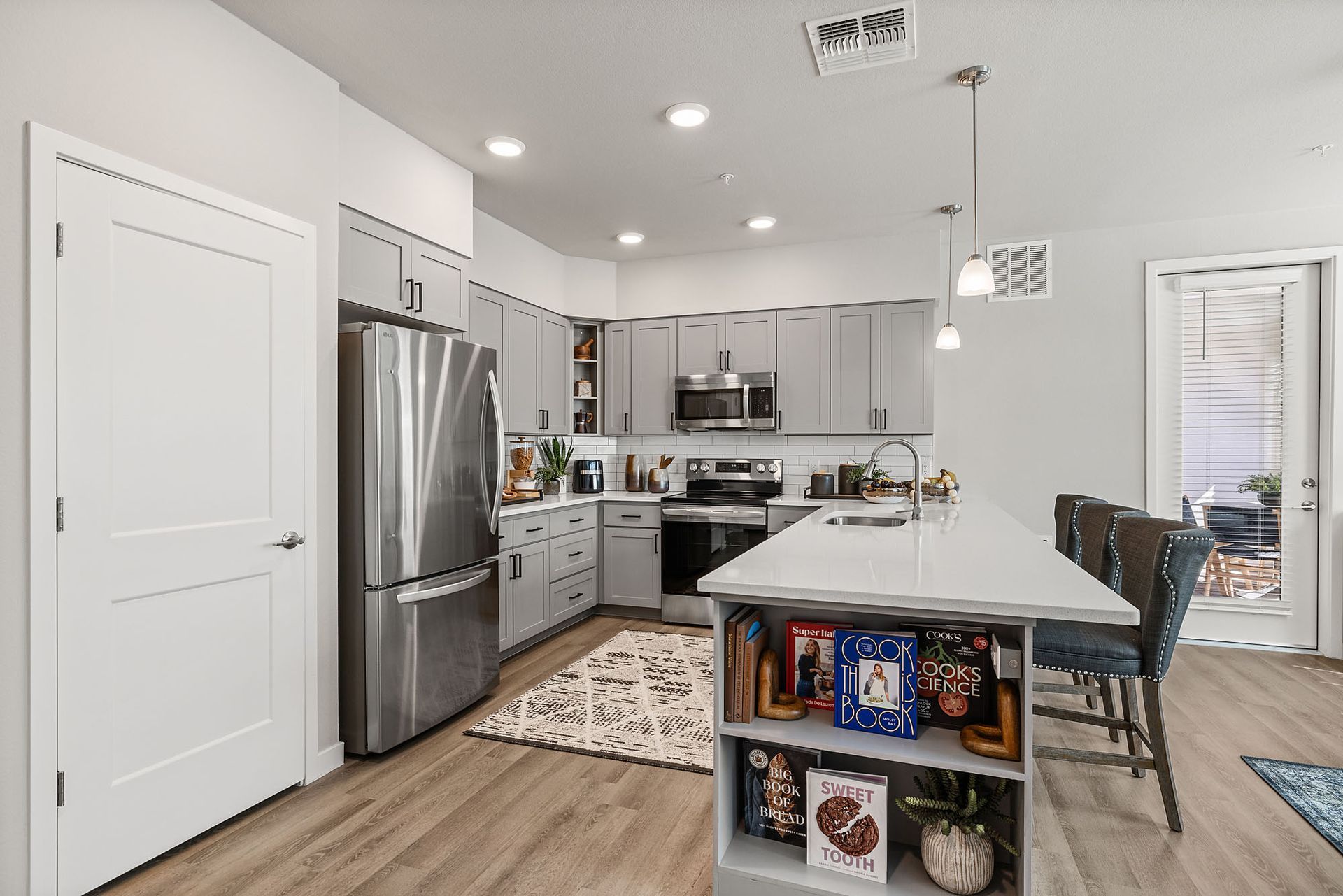 Modern kitchen with grey cabinets, stainless steel appliances, and a white island at Marq Bronco Butte, offers apartments in North Phoenix, AZ.