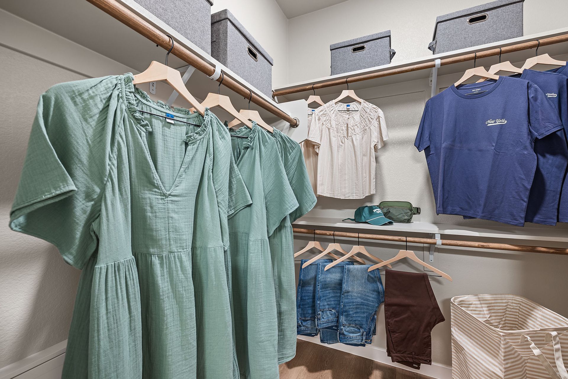 Closet with hanging clothes in various colors, shelves with storage bins at Marq Bronco Butte, offers loft-style apartments in North Phoenix, AZ.