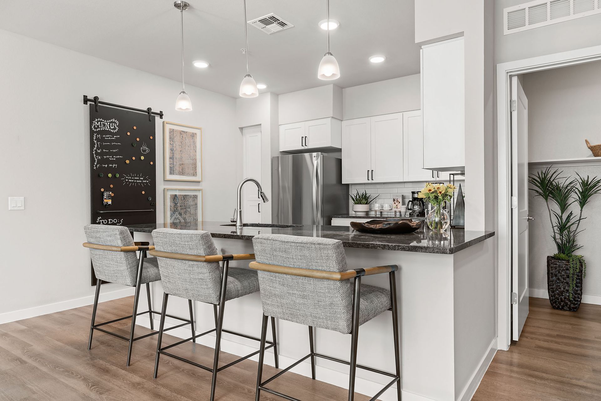 Modern kitchen with island, stainless steel appliances, and bar seating at Marq Bronco Butte, offers pet-friendly apartments in North Phoenix, AZ.