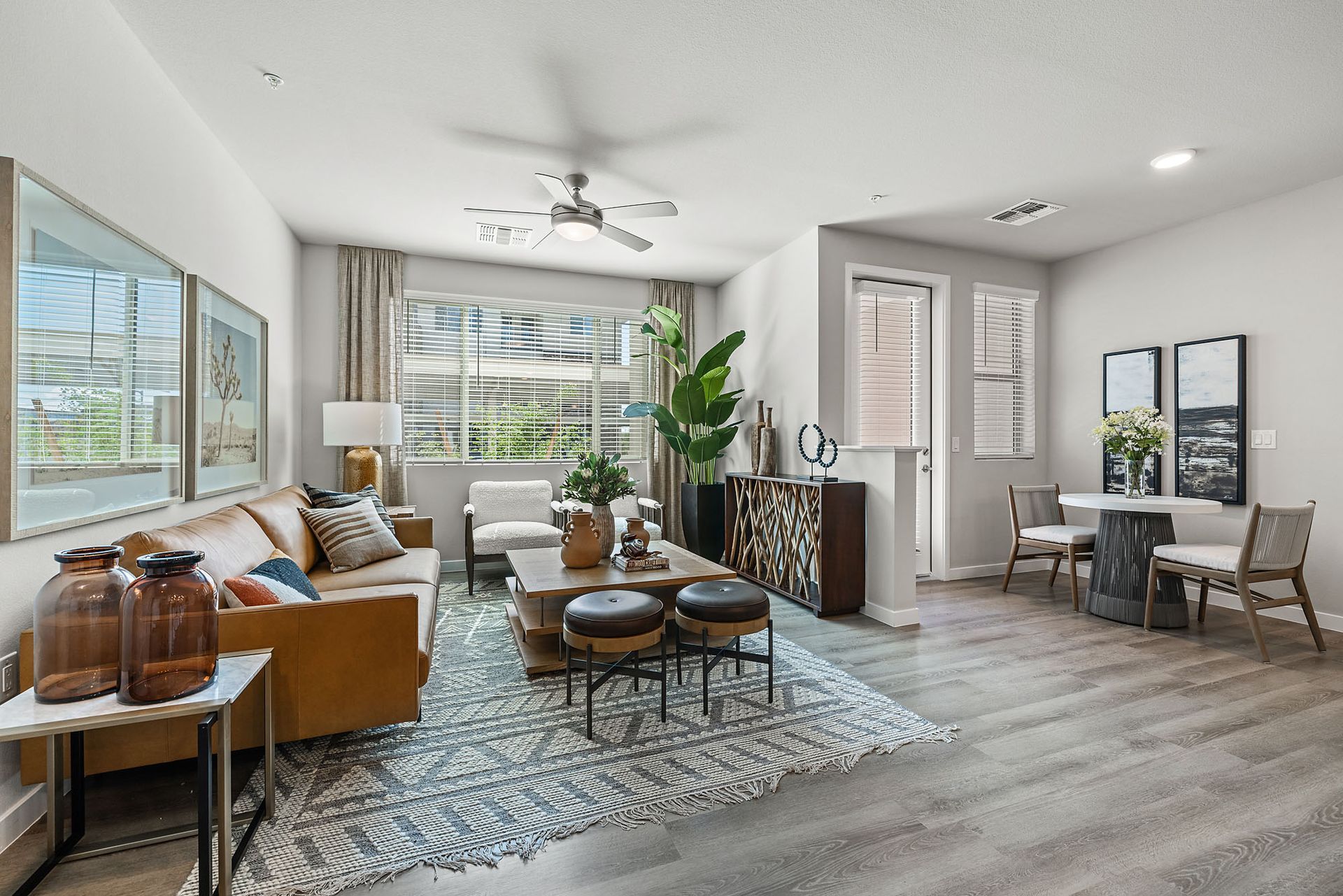 Living room with neutral tones, patterned rug, sofa, chairs, and decorative elements at Marq Bronco Butte, offers pet-friendly apartments in North Phoenix, AZ.