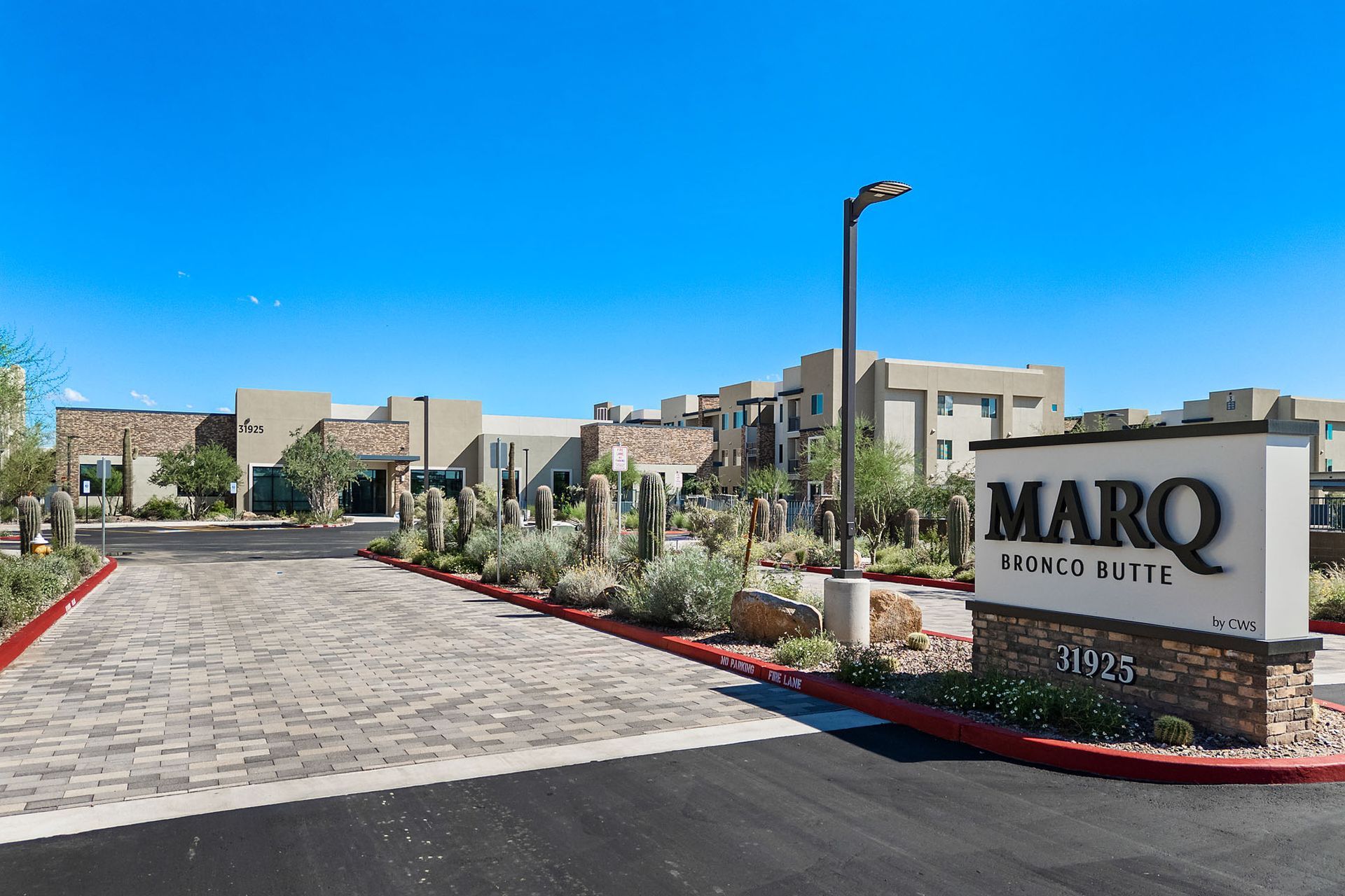 Entrance to MARQ at Kierland luxury apartments with sign, landscaping, and blue sky at Marq Bronco Butte, offers 1, 2, and 3 bedroom apartments in North Phoenix, AZ, with EV charging stations.