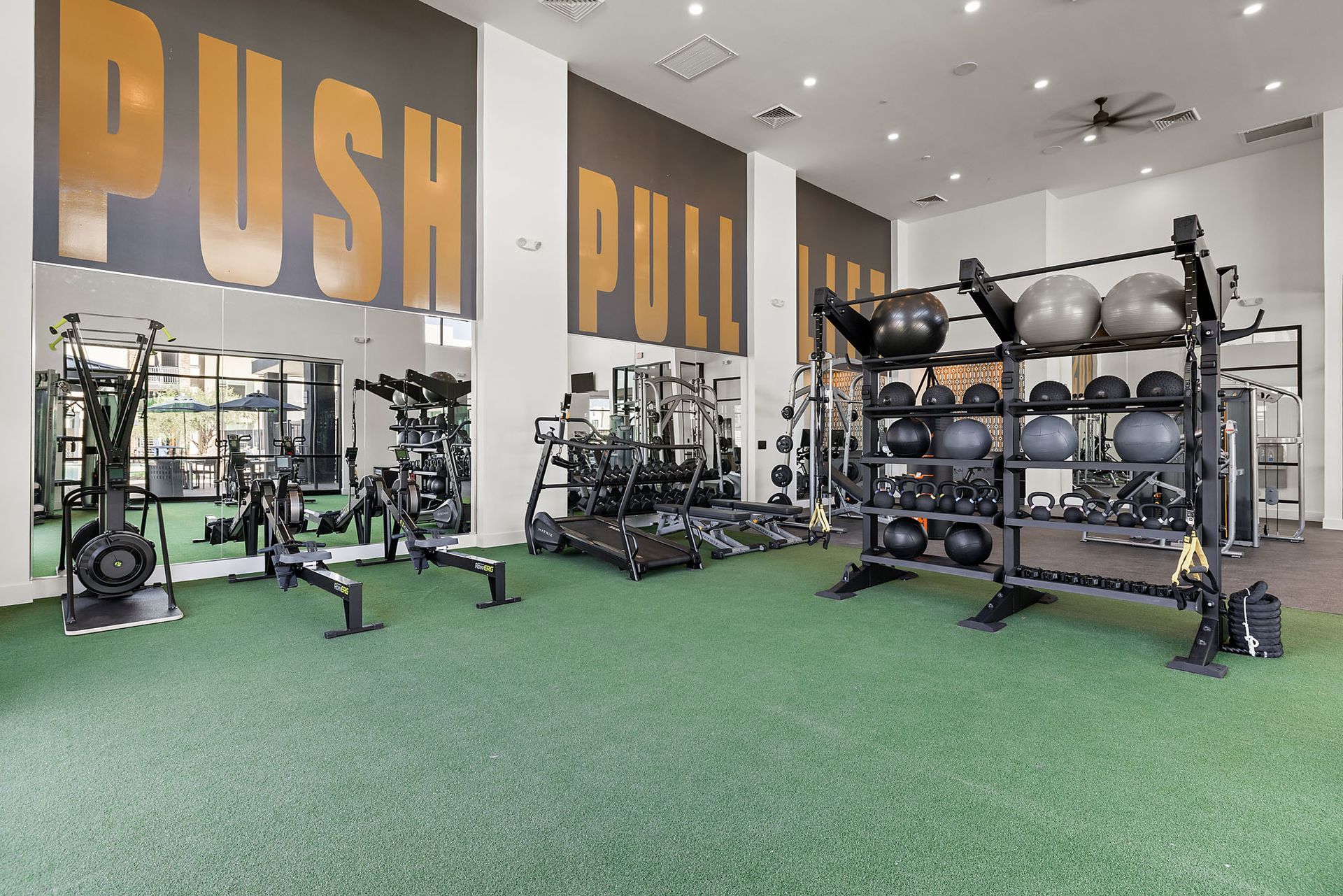 Gym interior with weight equipment, green floor, and words