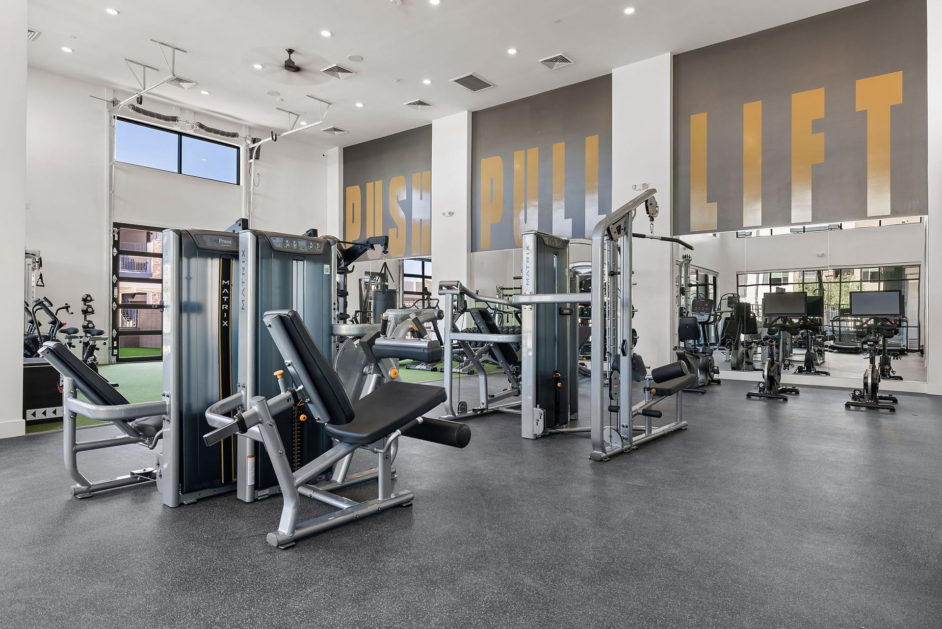 Gym interior with weight machines, dark floor, and