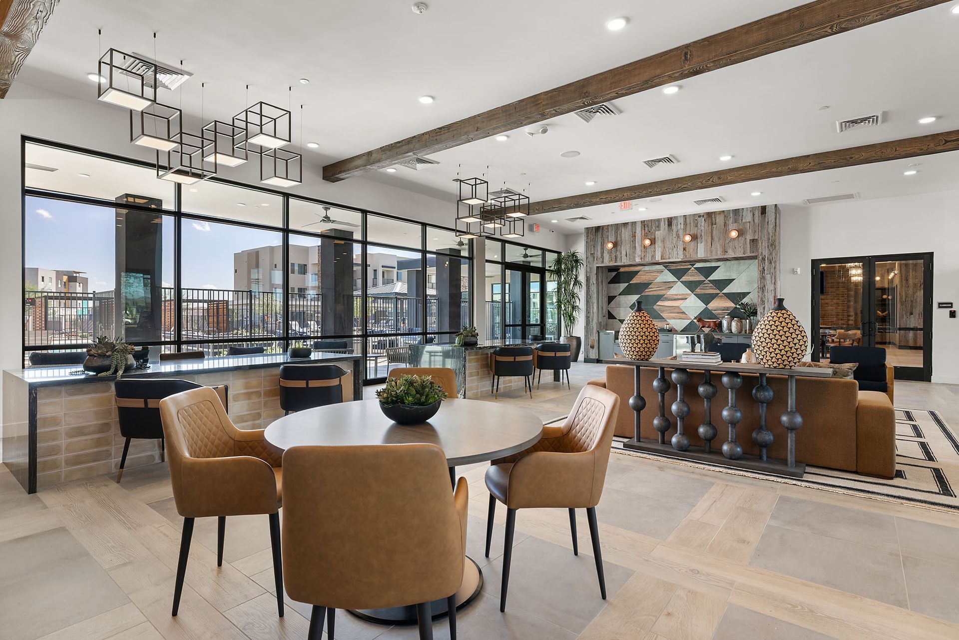 Lounge with round table, chairs, large windows, wood beams at Marq Bronco Butte, offers brand-new apartments for rent in North Phoenix, AZ. Neutral colors, modern style.