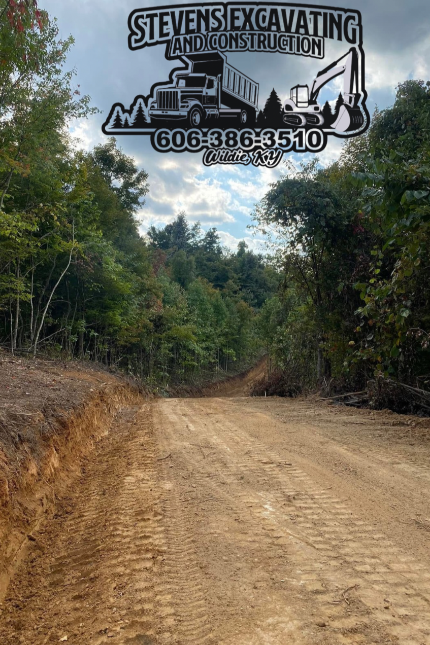 Gravel road cleared through trees, with