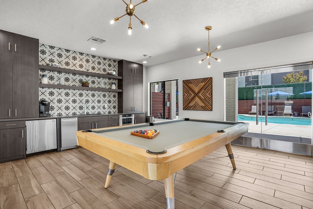 Telegraph Hill community recreation room with a pool table, kitchenette, and glass doors to the pool area.