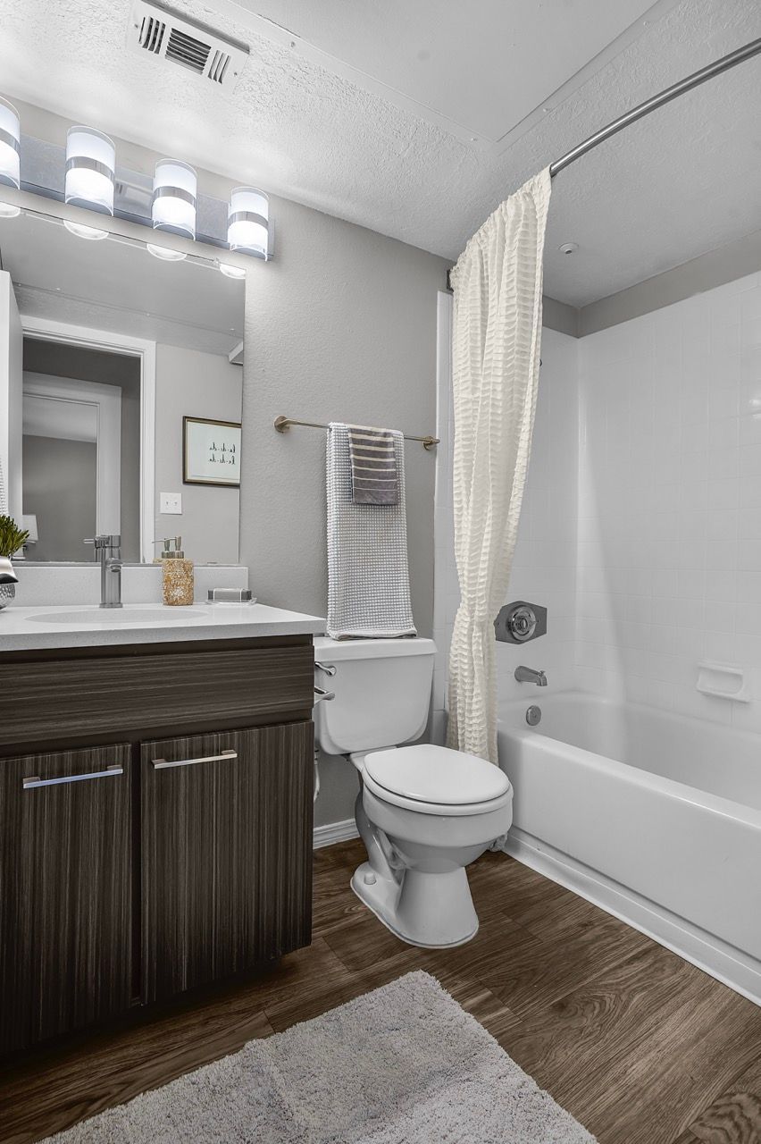 Bathroom in apartment unit with vanity, mirror, toilet, and bathtub/shower.